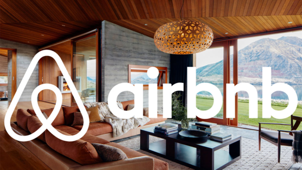 Image of an open plan room with the Airbnb logo over the top
