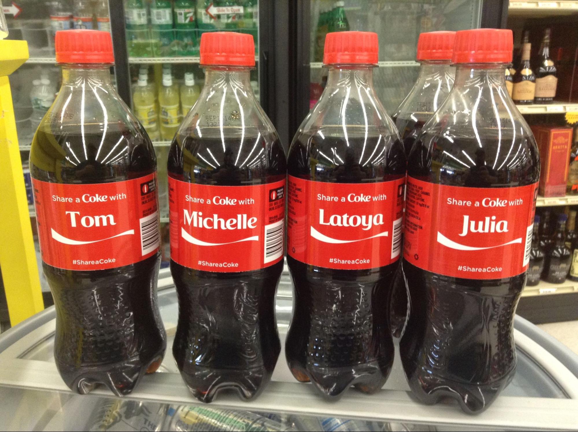 A photo of bottles of Coca-Cola with names on and the words "share a coke with"